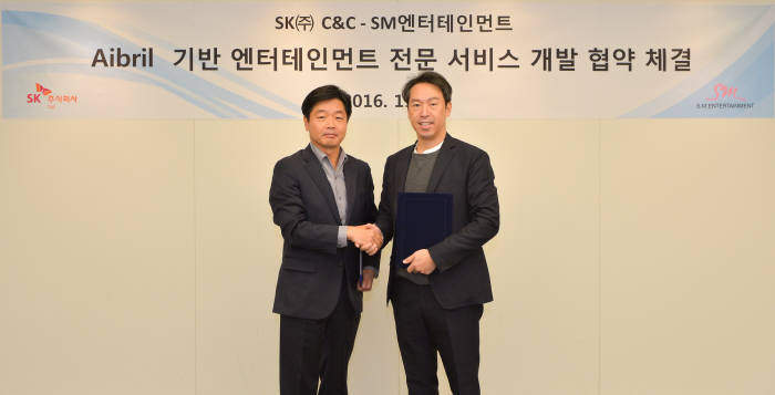 이기열 SK주식회사 디지털/금융사업부문장(왼쪽)과 김영민 SM엔터테인먼트 대표가 기념사진을 찍고 있다.
